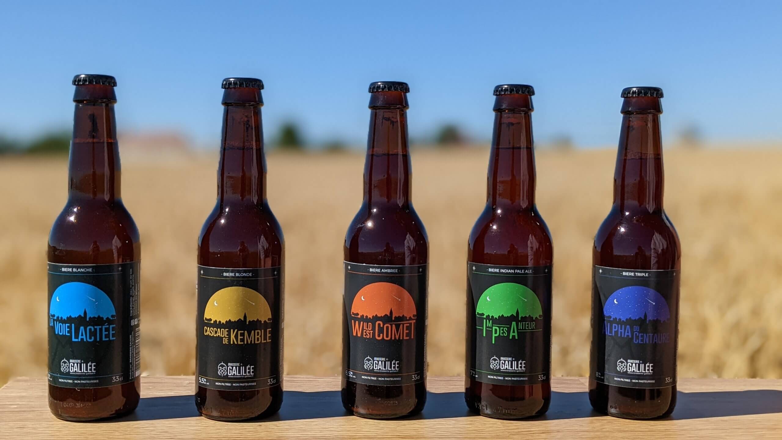 les 5 bières de la gamme Galilée avec un champ en arrière-plan