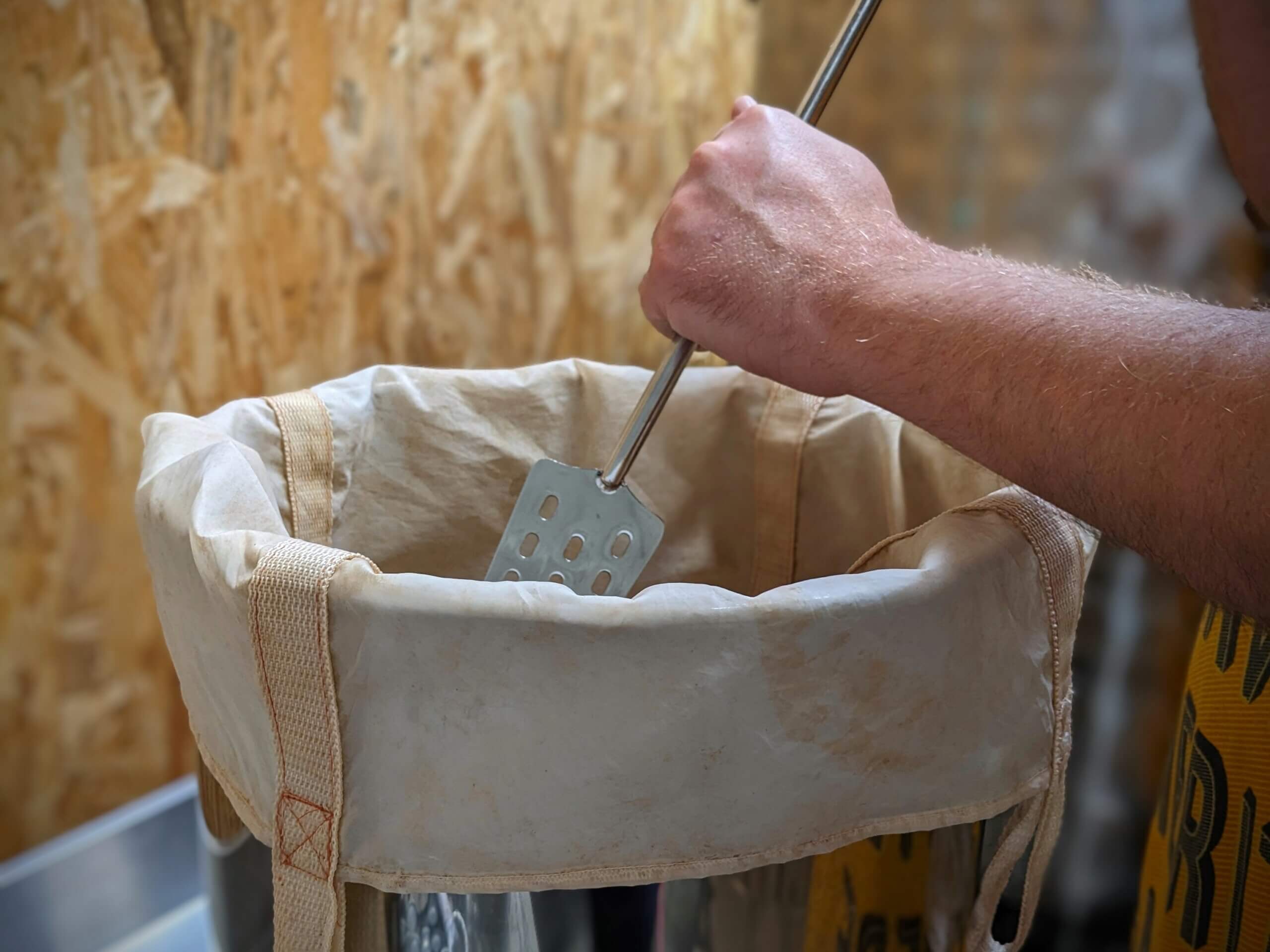 main en train de mélanger dans une cuve de brassage