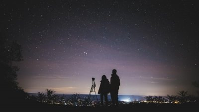 silhouettes d'un homme et un enfant regardant le ciel étoilé la nuit